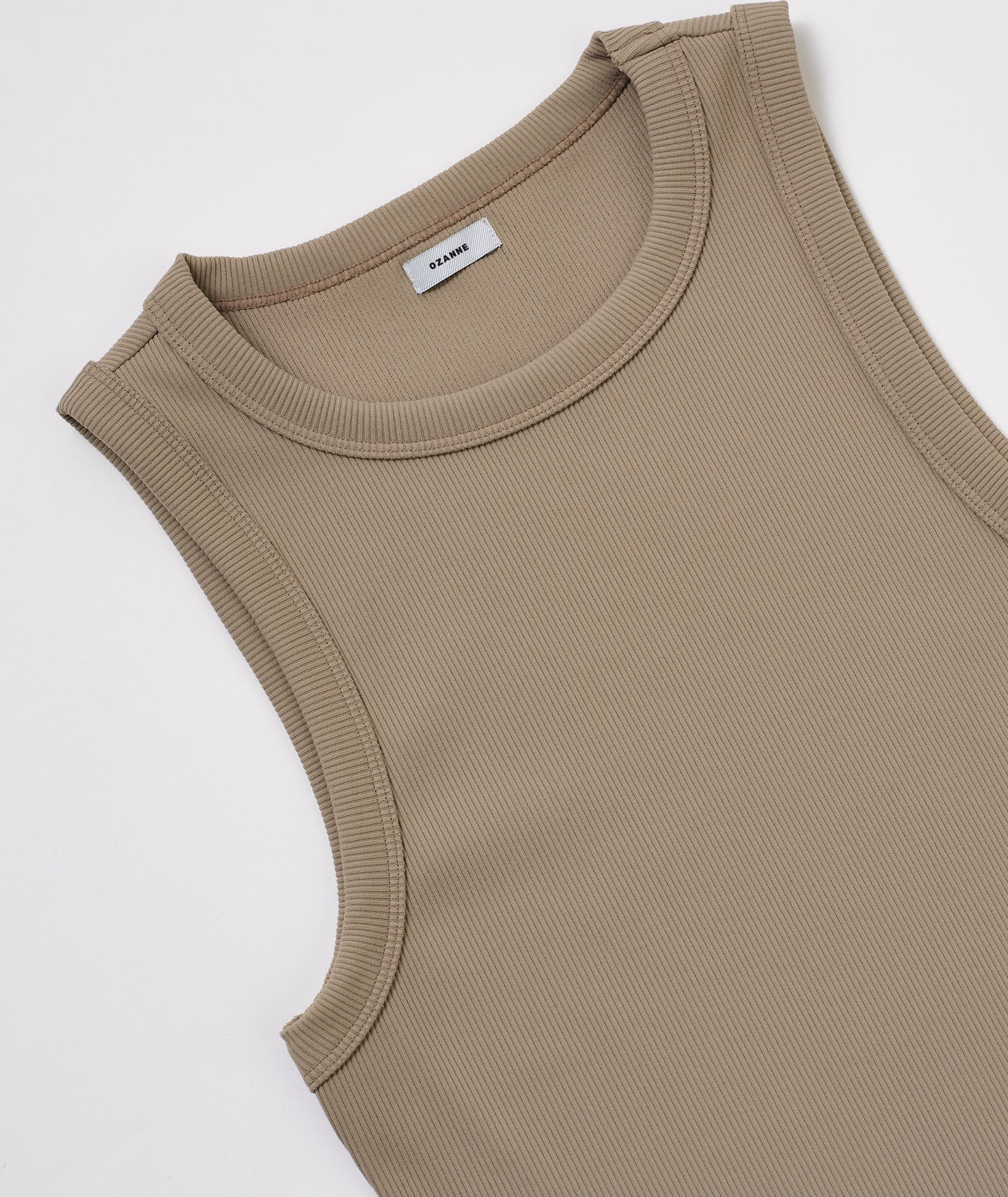 A beige sleeveless top is shown in the image.